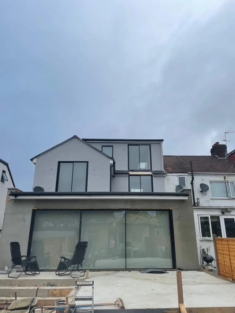 A finished rendered extension with full-width glazing and an upper-floor dormer